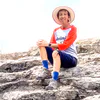 Middle-aged woman sitting on a rock ledge during a hike on Drummond Island.